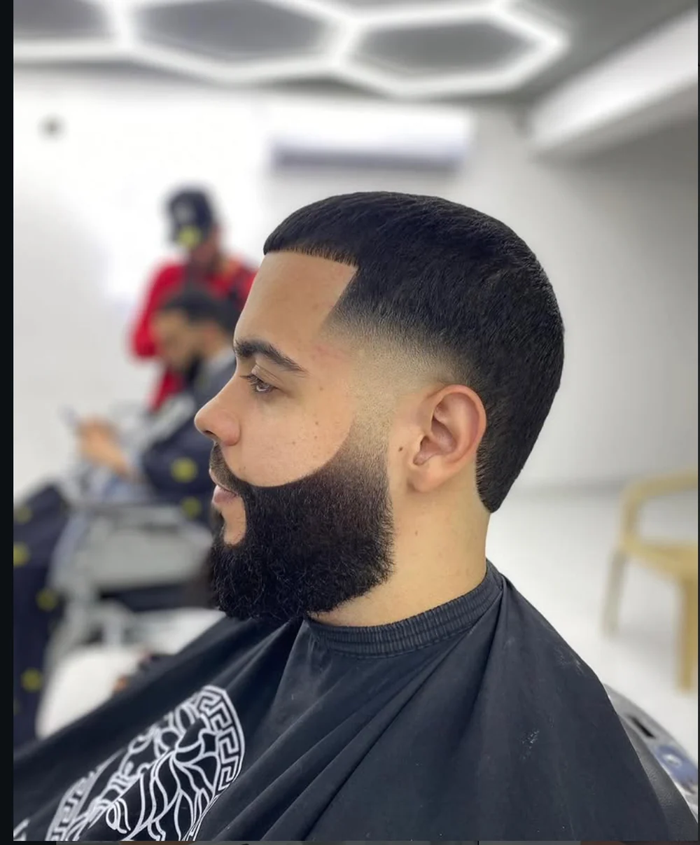 Corte moderno con degradado y barba definida