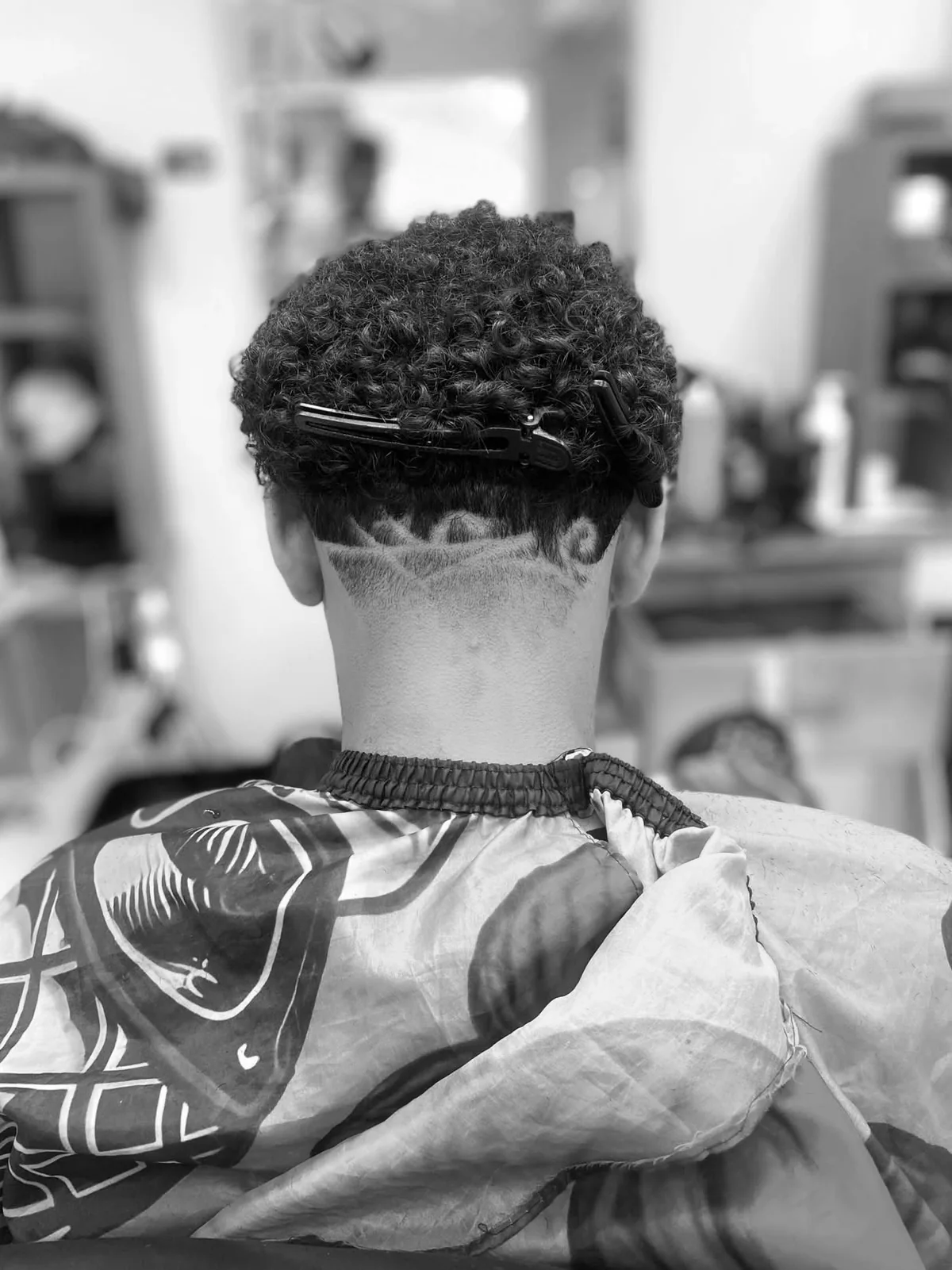 Diseño de corte en cabello rizado realizado por Barberia Los Muchachos